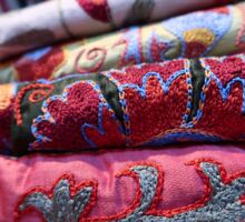 bestickte usbekische Decken in Rot und Dunkelgrün auf einem Stapel
