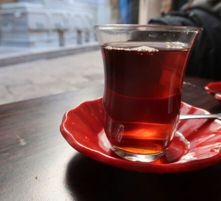 ein Glas Tee mit rotem Unterteller
