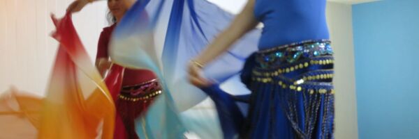 zwei Tänzerinnen mit Schleiern in Rot und Blau
