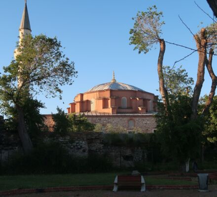 die kleine Hagia Sophia, ein rötliches Kuppelgebäude, eingerahmt von zwei Bäumen