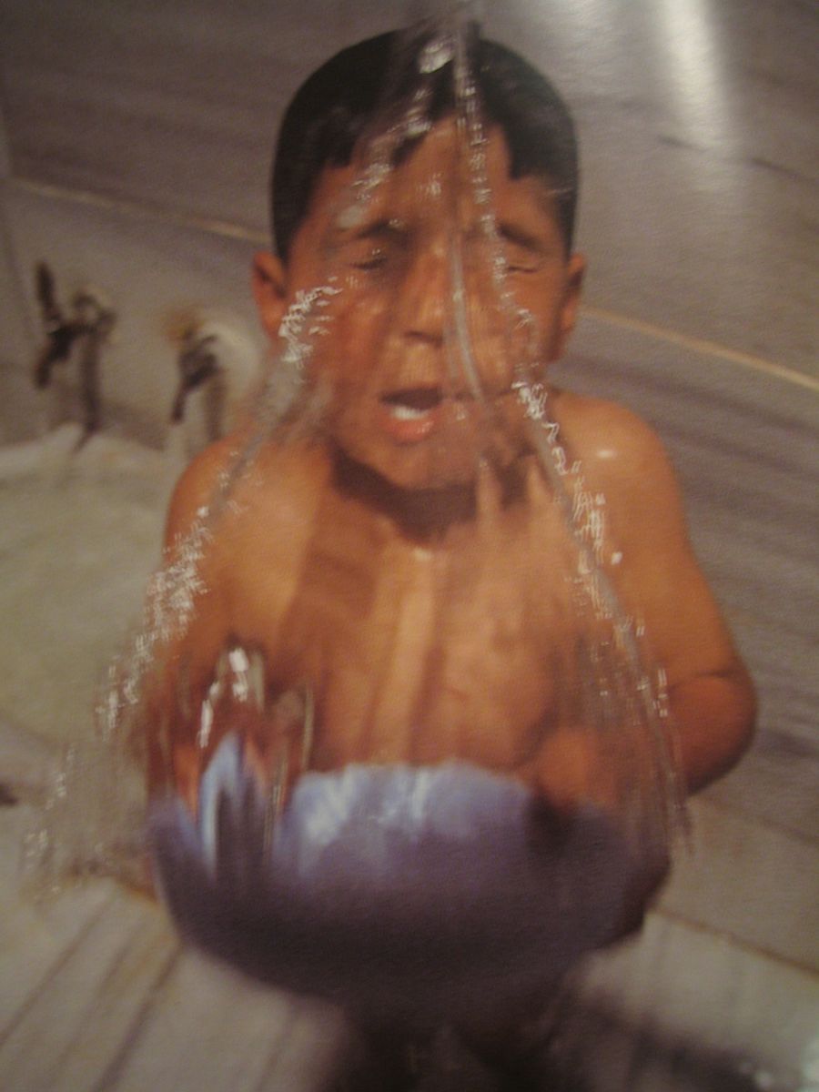 ein Kind wird mit kaltem Wasser übergossen
